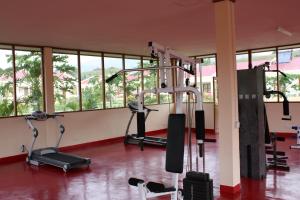 a gym with several tread machines in a room with windows at Malinamoc Paradise in Dili