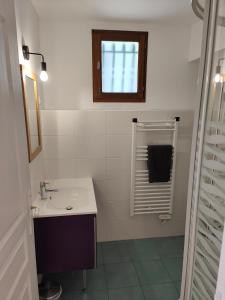 uma casa de banho branca com um lavatório e uma janela em Appartement Boutx em Boutx