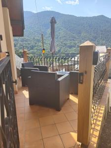 a balcony with chairs and an umbrella and a view at Appartement Boutx in Boutx