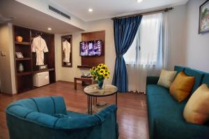 - un salon avec deux canapés bleus et une table dans l'établissement Aviary Hanoi Hotel & Travel, à Hanoï