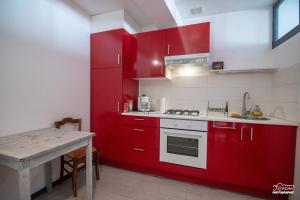 uma cozinha com armários vermelhos e uma mesa em Hyper centre - wifi - cosy - Gare em Bourg-en-Bresse