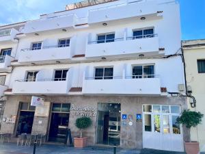 a white building with a balcony at Apartamentos Frontera in Frontera