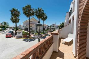 a balcony with a view of a street with palm trees at Apartamento 2 Dormitorios con vistas al Mar in Nerja