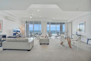 een woonkamer met witte meubels en uitzicht op de oceaan bij Oceana On Broadbeach in Gold Coast