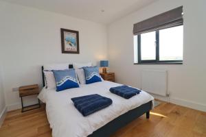 a bedroom with a bed with blue pillows on it at Stunning home, sea views, walk to beach in Saint Ervan