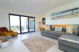 a living room with a couch and a chair at Stunning home, sea views, walk to beach in Saint Ervan