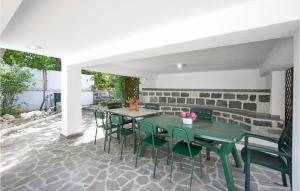 eine Terrasse mit zwei grünen Tischen und Stühlen in der Unterkunft Cozy Home In Villa San Giovanni With Kitchen in Villa San Giovanni