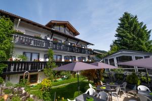 un hotel con un patio al aire libre con mesas y sombrillas en 180Gradblick, en Kierwang