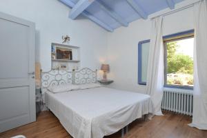 Habitación blanca con cama y ventana en Villa Borgiano, en Scansano