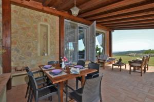 un patio con mesa de madera y sillas en Villa Borgiano, en Scansano
