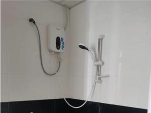een douche in een witte muur met een douche bij Family Suites at Mansion One by MAJ in George Town