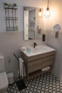 W łazience znajduje się umywalka, toaleta i lustro. w obiekcie Torre de Ambroz w mieście Plasencia