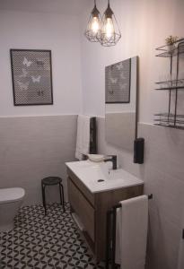 uma casa de banho com um lavatório, um WC e um espelho. em Torre de Ambroz em Plasencia
