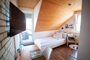 a living room with a white couch and a tv at PIEPers Landidyll Hotel in Bad Laer