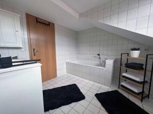 ein weißes Badezimmer mit einer Badewanne und einem Waschbecken in der Unterkunft Haus Andreas in Bodenmais