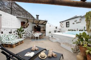 eine Terrasse mit einem Tisch, Stühlen und einem Pool in der Unterkunft Casa Pedro in Icod de los Vinos