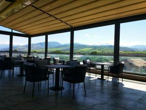 Un restaurante con mesas y sillas y vista a las montañas. en Turon Telecom Hotel, en G‘azalkent