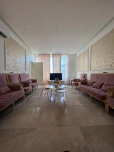 sala de estar con sofás, mesa y TV en شاليه كادي cady resort en Al Khobar