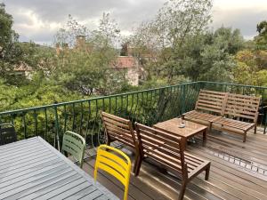 a deck with two benches and a table and chairs at Les cigales in Le Lavandou
