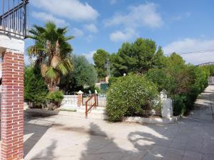 een stenen huis met een hek en een palmboom bij Casa Martin in Murcia