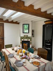 una mesa con comida en una habitación con chimenea en Maison cosy avec jardin en plein centre historique, en Orbec-en-Auge