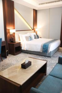 فندق ليفيل ناين Level Nine Hotel في جدة: غرفة بالفندق بها سرير وطاولة قهوة