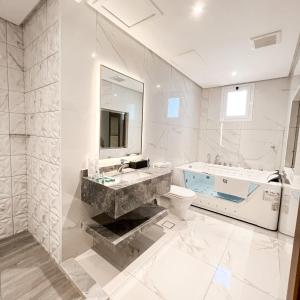 فندق ليفيل ناين Level Nine Hotel في جدة: حمام مع حوض ومرحاض وحوض استحمام