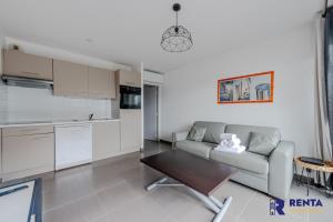 sala de estar con sofá y mesa en Le Backspin - Appartement moderne avec terrasse, en Saint-Cyprien