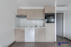cocina blanca con fregadero y nevera en Le Backspin - Appartement moderne avec terrasse, en Saint-Cyprien