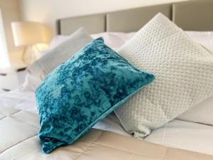 2 almohadas sentadas encima de una cama en Gild House 2-bedroom apartment close to Town Centre en Bournemouth