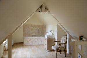 a bathroom with a sink and a chair in a attic at Domaine de la Trigalière in Ambillou