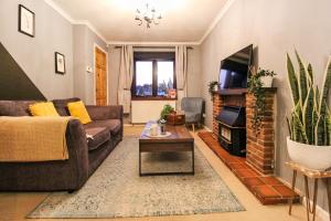 a living room with a couch and a tv at Comfortable 2 Bedroom House with Free Parking in Nottingham