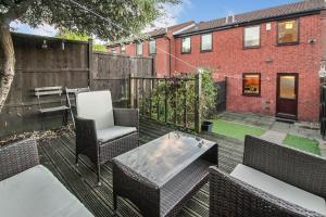 um pátio com cadeiras, uma mesa e uma cerca em Comfortable 2 Bedroom House with Free Parking em Nottingham