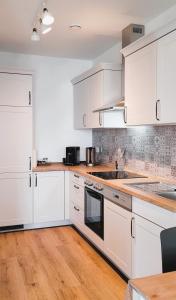 a white kitchen with white cabinets and wooden floors at Wine & Hike in Wincheringen