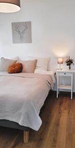 1 dormitorio con 1 cama y 1 mesa con lámpara en Wine & Hike, en Wincheringen