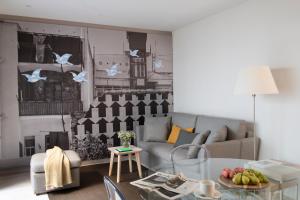 - un salon avec un canapé et une table dans l'établissement Eric Vökel Boutique Apartments - BCN Suites, à Barcelone