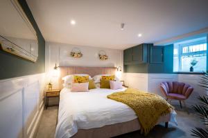 a bedroom with a large bed and a chair at Mulberry in Windermere