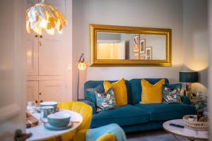 sala de estar con sofá azul y espejo en Mulberry, en Windermere