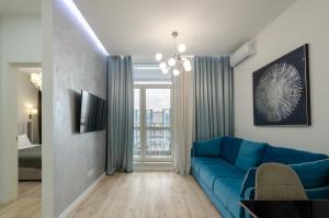 un soggiorno con divano blu e finestra di 28485 Central park apartments a Kiev