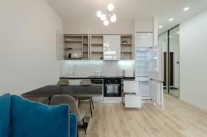 kuchnia z białymi szafkami i niebieską kanapą w obiekcie 28485 Central park apartments w Kijowie