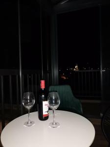 a bottle of wine and two glasses on a table at Apartment Lukavica in Lukavica +4 photos