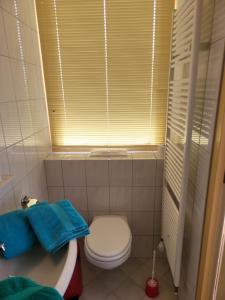 a bathroom with a toilet and a sink and a window at Pension Canberra in Bergen aan Zee +14 photos