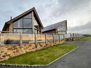 a house with a stone wall and windows at Pendle View by Valley View Lodges in Longridge