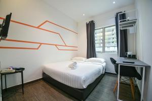 a bedroom with a bed and a desk and a window at Meta Hotel in Kuala Lumpur