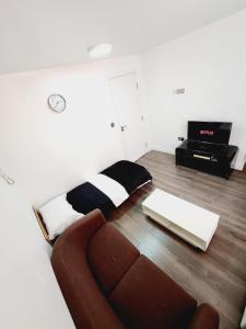 a living room with a couch and a tv at City centre lovely Apartment with the Cheapest Overnight Parking in Leicester