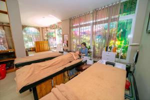 a person sitting in a room with several beds at Khách sạn Vĩnh Hội in Pleiku