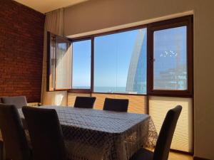 a table and chairs in a room with a large window at Park Azure Sky apartment in Baku