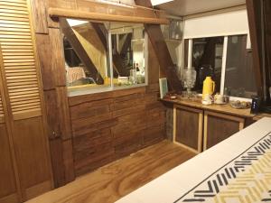 a room with wood paneling and a counter with a window at Hostal La Minga in Chaitén