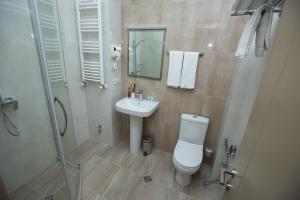 a bathroom with a toilet and a sink and a shower at History Hotel Tbilisi in Tbilisi City