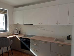 una cucina con armadi bianchi e lavandino di Bel Dom - The Central, spacious 2 rooms luxury apartment a Cluj-Napoca
